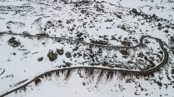 雪に覆われた山道と峰がある山岳風景の空中写真 — ストック写真