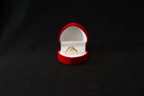 Egy Piros Doboz Közelsége Arany Gyűrűvel Egy Fekete Felületen — Stock Fotó