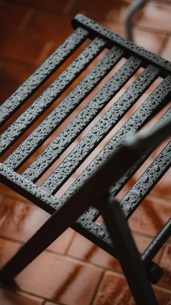 Yağmurda Dışarıda Siyah Katlanır Bir Sandalyenin Dikey Görüntüsü — Stok fotoğraf