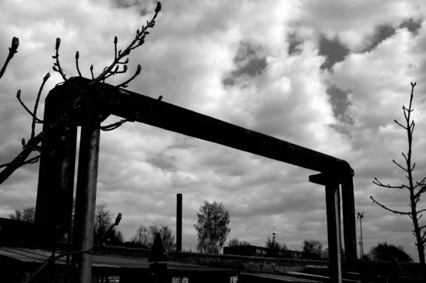 鉄道駅のバー上の産業用曲線を持つ巨大な金属管のグレースケールビュー — ストック写真