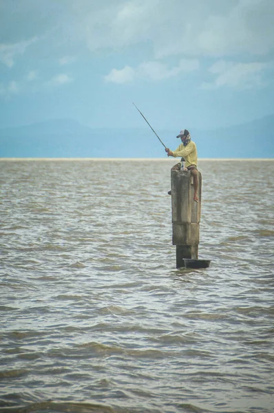 Disparo Vertical Una Persona Pescando Sentada Muelle Mar — Foto de Stock