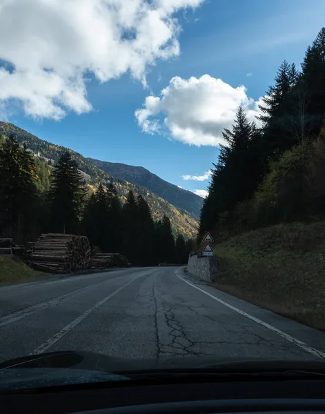 その前にアルプスの山々と電気自動車のフロントガラスの後ろから移動中のショット 寒い曇りの秋の日 ハメ撮り一人称視点 — ストック写真