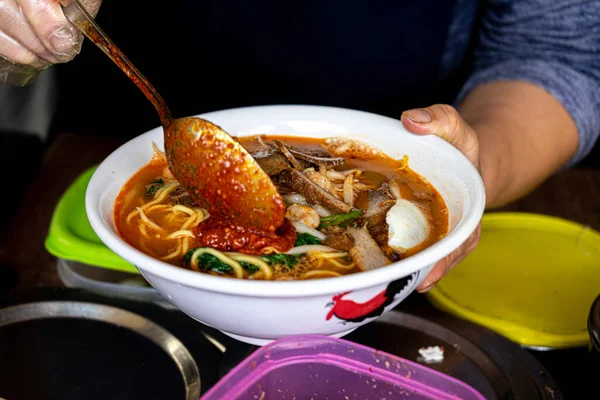 自家製のおいしいアジアの麺スープを混合する人 — ストック写真