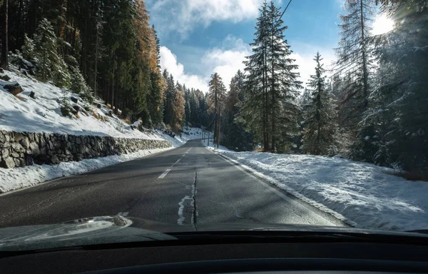 雪に覆われたアルプスの山々と電気自動車のフロントガラスの後ろから移動中のショット 寒い曇りの秋の日 — ストック写真