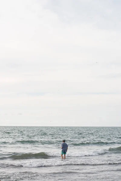 Vertical Shot Person Alone Beach Cloudy Sky Background — Zdjęcie stockowe