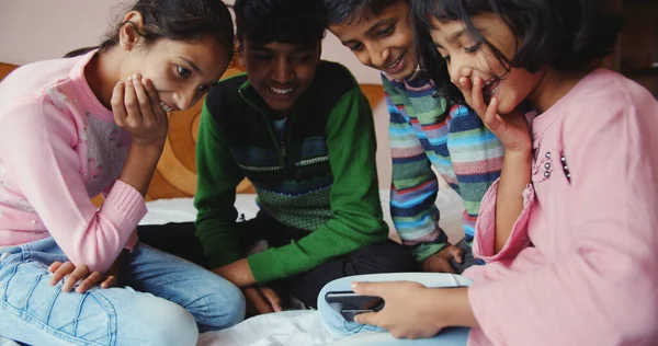 Closeup Four South Asian Siblings Watching Videos Mobile Phone Home — Foto de Stock