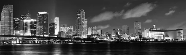 stock image A grayscale pano shot of a cityscape and a moving sky in the night.