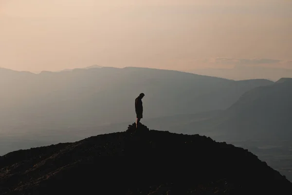 Μια Σιλουέτα Ενός Ανθρώπου Στην Κορυφή Ενός Βουνού Στο Ηλιοβασίλεμα — Φωτογραφία Αρχείου