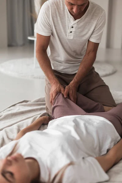 Jovem Profissional Massageando Pernas Uma Mulher Quarto Aconchegante Branco Durante — Fotografia de Stock