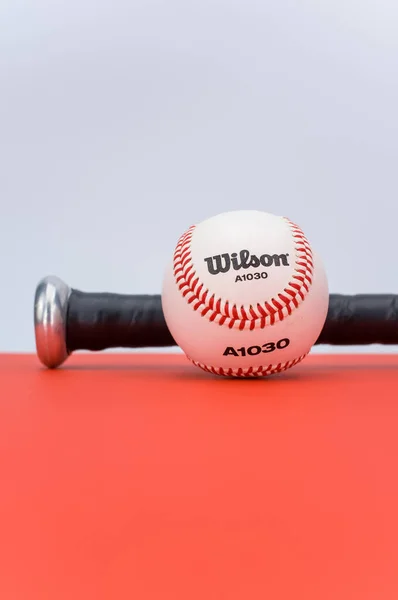 Inverigo Itálie Prosinec 2021 Izolovaný Baseballový Míč Pálka Červeném Pozadí — Stock fotografie