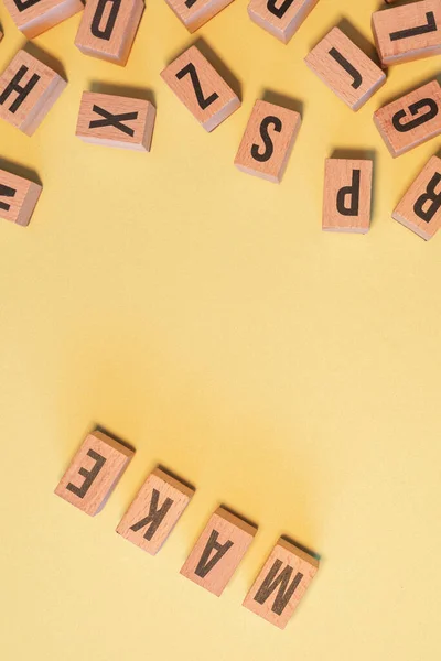 Word Make Taken Pile Wooden Letter Blocks Vertical Yellow Background — Stockfoto
