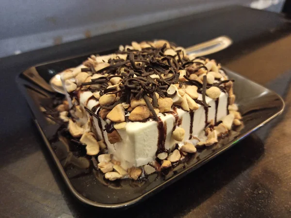 選択的フォーカスチョコレートソースとバニラアイスの写真はナッツで滴下 アイスクリームは夏に食べるのに最適なデザートです — ストック写真