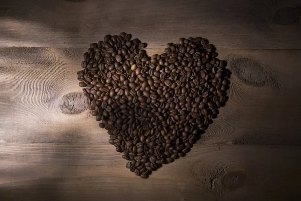 Вид Сверху Свежие Жареные Кофейные Зерна Положить Сердце Shaoe Деревянный — стоковое фото