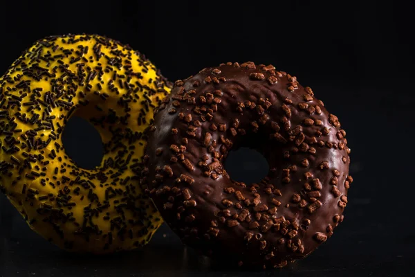 Eine Nahaufnahme Von Donuts Mit Glasierten Streusel Auf Schwarzem Hintergrund — Stockfoto