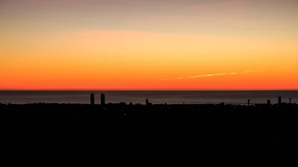 オレンジ色の夕日の海岸沿いの町や海の空の景色 — ストック写真