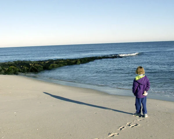 Ребенок Стоит Песчаном Берегу Смотрит Океан — стоковое фото