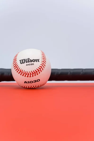 Inverigo Itálie Prosinec 2021 Izolovaný Baseballový Míč Pálka Červeném Pozadí — Stock fotografie