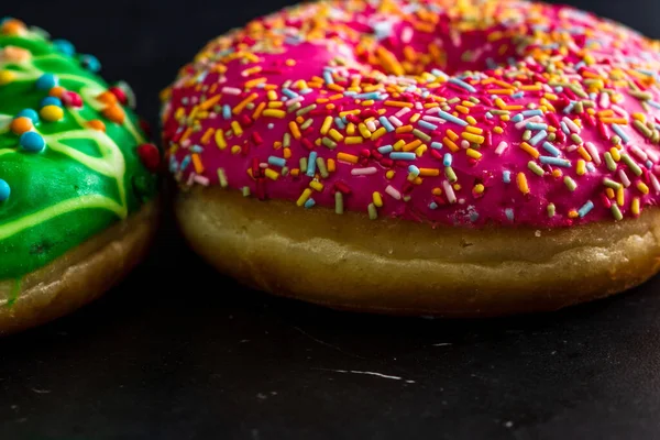 Closeup Shot Donuts Glazed Sprinkles Black Background — Stockfoto