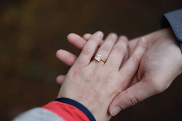 婚約指輪付きの女性の手を握っている男性の手のクローズアップショット — ストック写真