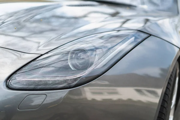 Een Close Opname Van Een Koplamp Van Een Grijze Auto — Stockfoto