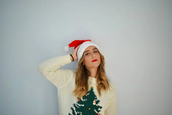サンタクロースの帽子をかぶった白人女性とクリスマスツリーのセーター — ストック写真