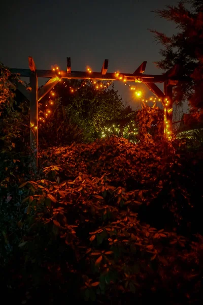 Pionowe Ujęcie Podświetlanych Świateł Strunowych Drewnianym Ogrodzeniu Zewnątrz — Zdjęcie stockowe