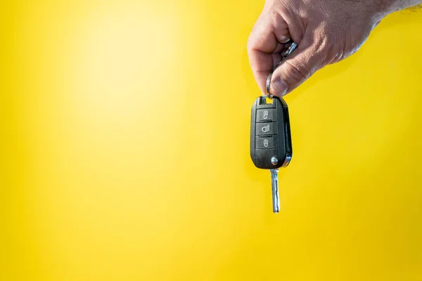 Closeup Shot Male Hand Holding Car Key Illuminated Yellow Background — Fotografia de Stock