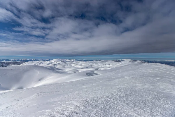 Ett Landskap Pister Kullar Täckt Snö Molnig Himmel — Stockfoto