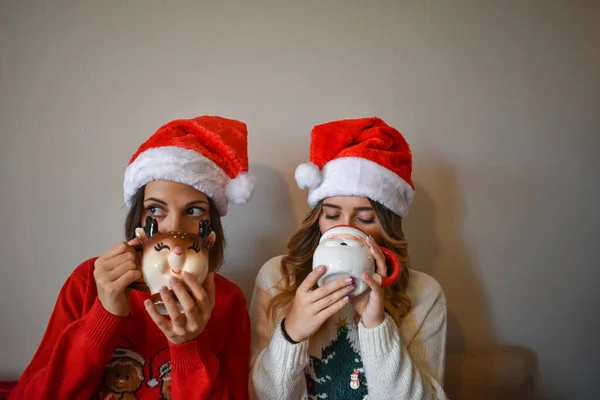 Dos Mujeres Caucásicas Usando Sombreros Santa Claus Bebiendo Chocolate Caliente — Foto de Stock