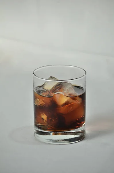 白い背景にガラスのカップに冷たい氷の飲み物の垂直閉鎖 — ストック写真