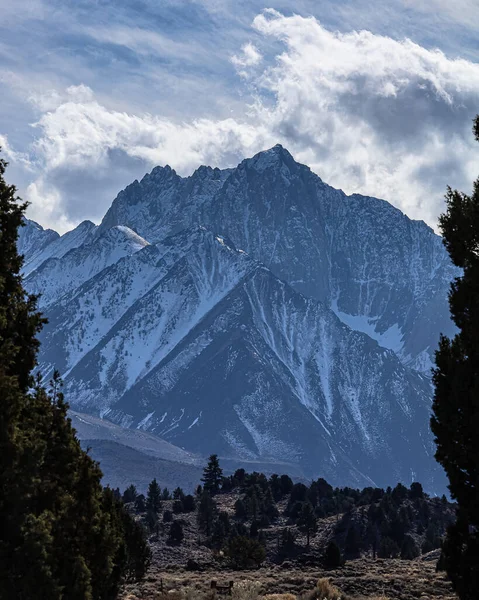 Bulutlu Bir Arka Planda Karla Kaplı Kayalık Bir Dağın Dikey — Stok fotoğraf