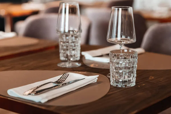 餐桌上有眼镜 叉子和刀具的双人桌 放在餐馆的木制桌子上 — 图库照片