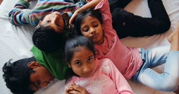 Overhead Shot Four South Asian Kids Lying Bed — Stockfoto