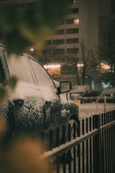 在冬天的傍晚 一辆被雪覆盖的汽车的垂直镜头 — 图库照片