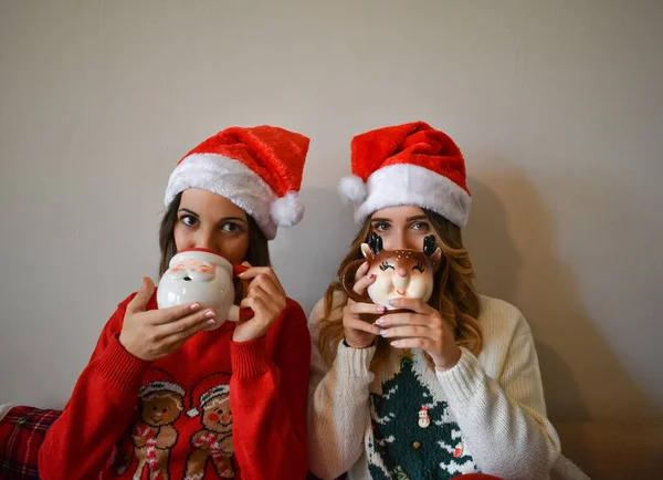 Dos Mujeres Caucásicas Usando Sombreros Santa Claus Bebiendo Chocolate Caliente — Foto de Stock