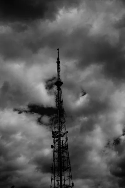 Een Grijsschaal Van Een Telecommunicatietoren Onder Bewolkte Lucht — Stockfoto