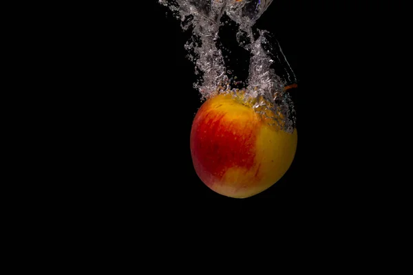 Closeup Shot Apple Falls Water Air Bubbles Splashes Black Background — Foto Stock