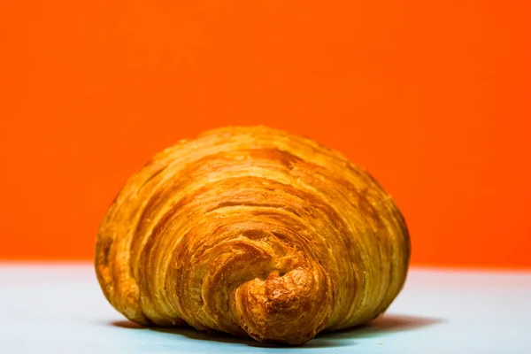 Nahaufnahme Eines Frischen Croissants Auf Orangefarbenem Hintergrund — Stockfoto