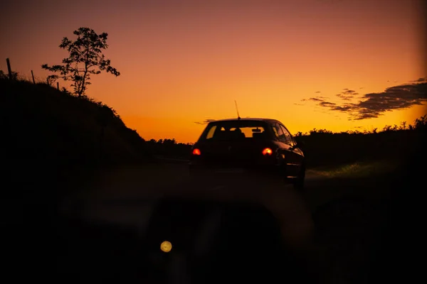Вид Сзади Автомобиля Проезжающего Дороге Через Поля Закате — стоковое фото