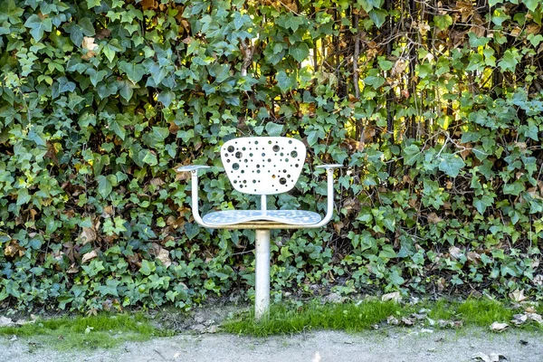 Duvarın Önündeki Metal Sandalye Halka Açık Parkta Yoğun Yeşil Yapraklarla — Stok fotoğraf
