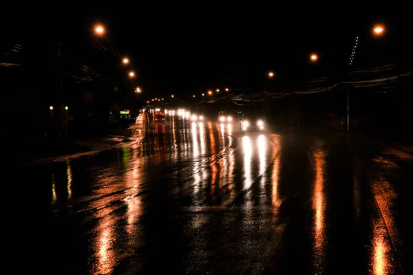在潮湿的道路上驾驶前灯的汽车的夜景 — 图库照片