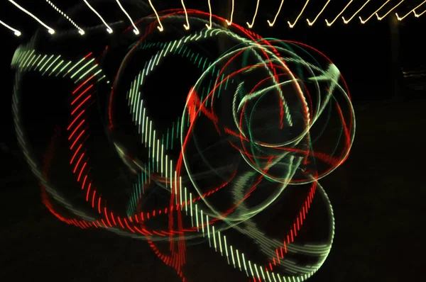 抽象的な緑の赤い渦巻きと黒い背景の曲線のデジタルレンダリング — ストック写真