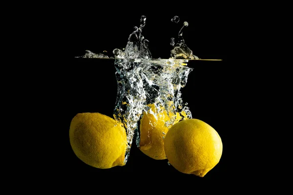 Свежие Лимоны Падение Воду Спрей Дизайна Изолированы Черном Фоне — стоковое фото