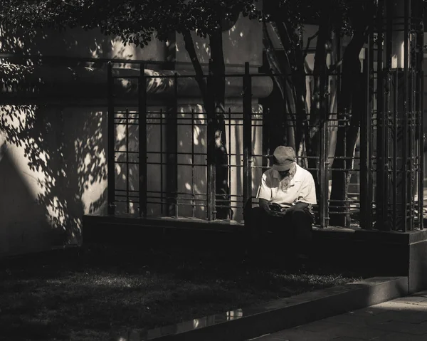 Ein Alter Mann Sitzt Draußen Und Schaut Auf Sein Handy — Stockfoto