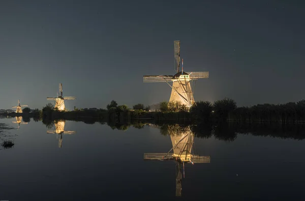 Die Beleuchteten Windmühlen Spiegeln Sich Der Nacht Auf Dem See — Stockfoto
