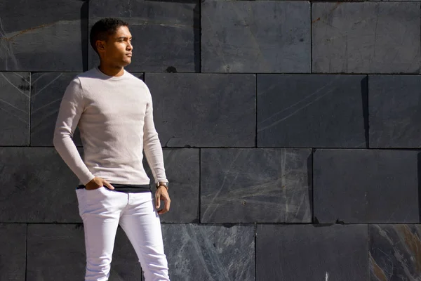 Muž Pózující Kalhotách Bílém Svetru Kamenným Pozadím — Stock fotografie