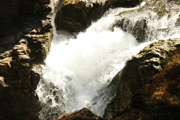 大きな岩の間の滝から流れる水蒸気のショット — ストック写真
