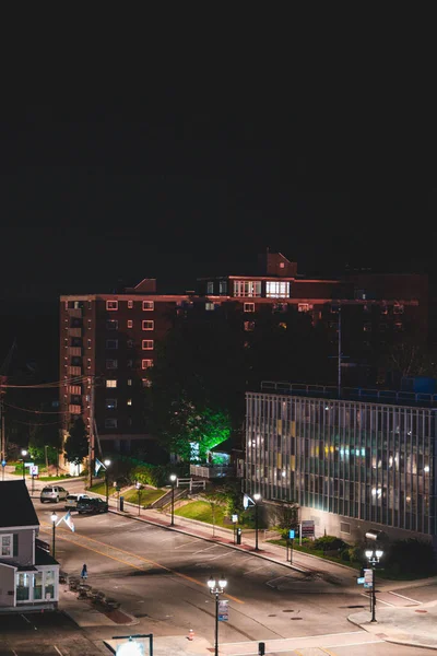建筑物和夜晚灯火通明的街道的垂直截图 — 图库照片