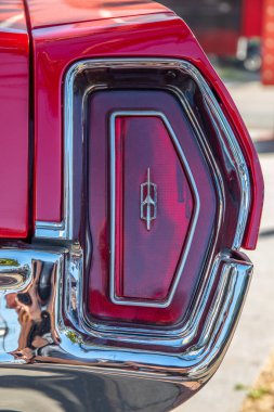 The red brake light or taillight of a red classic car or Muscle- Car in the streets clipart