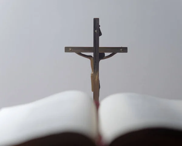 Selective Focus Picture Metal Cross White Background Blurry Book Foreground — Stock Photo, Image